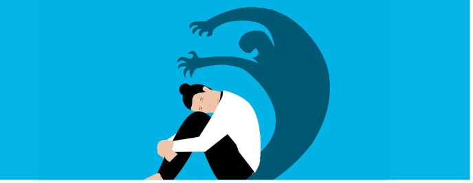 Person sitting with knees drawn up while a shadowy figure with clawed hands looms behind them, symbolizing workplace anxiety