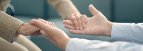 Two pairs of hands reaching toward each other in a gesture of comfort and support