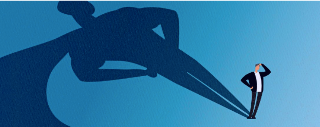 Illustration of a businessman whose shadow forms a superhero pose, symbolizing inner courage and fearlessness in workplace
