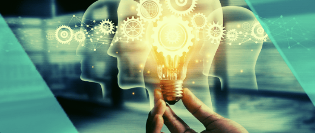 Hand holding a glowing light bulb with gears and human head silhouettes, symbolizing innovative thinking for employee